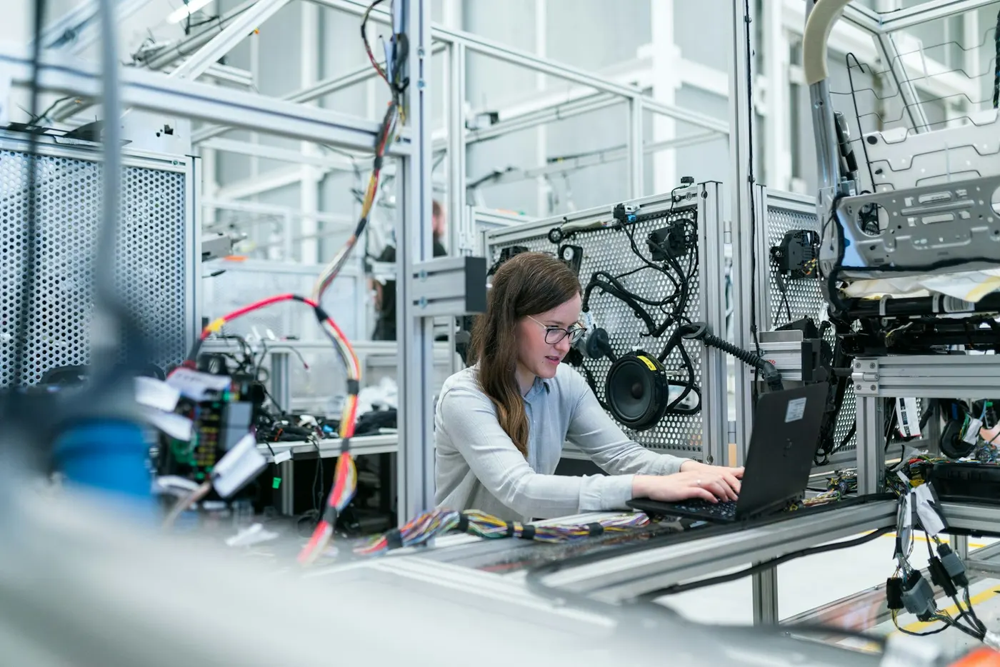 Technician working at a laptop on an assembly line